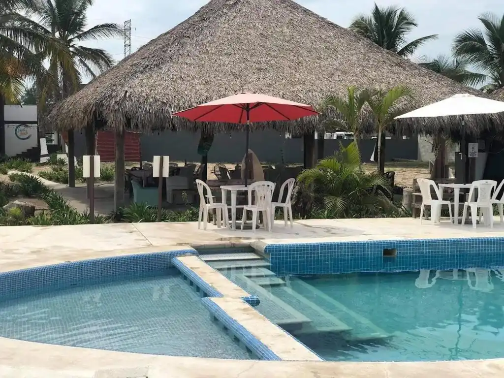 Outdoor palapa seating beside the pool